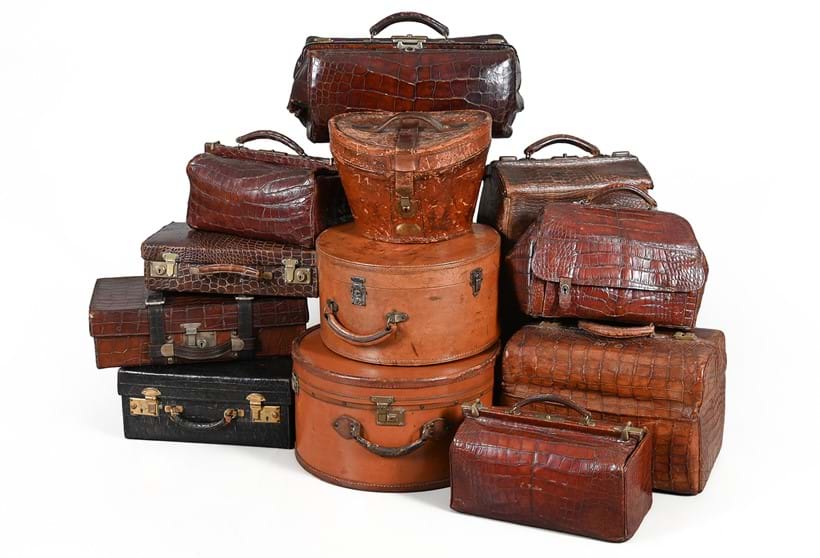 Inline Image - Lot 50: Y A collection of various luggage, to include a 'crocodile' leather traveling case with silver mounted dressing set, another larger without fittings, a brief case, three various hat boxes, six various 'crocodile' leather and other medical bags, clutch bag, two stationery cases and a jewellery box, etc | Est. £1,200-1,800 (+ fees)