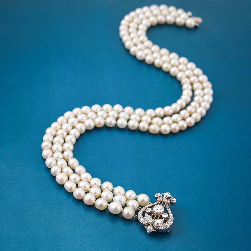 A three strand natural pearl necklace with late 19th century and later diamond clasp
