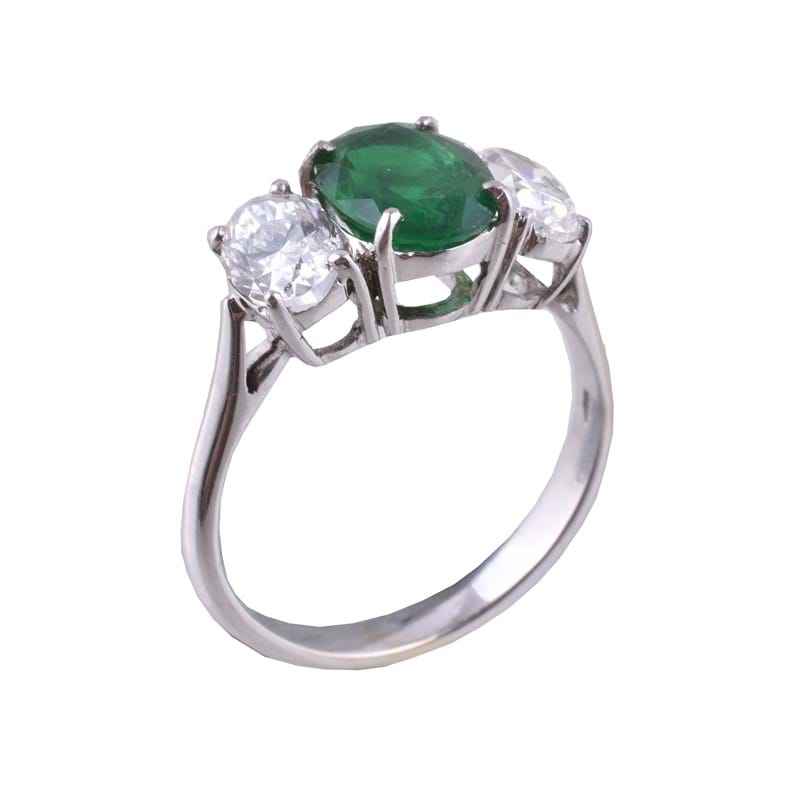 An emerald and diamond three stone ring 