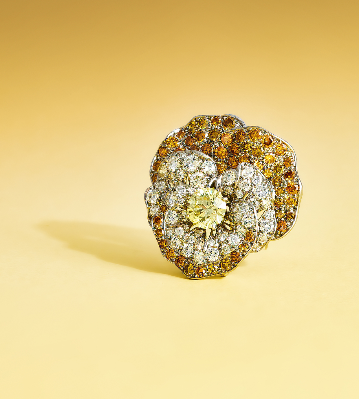 Inline Image - Oscar Heyman & Brothers, a coloured diamond and diamond 'Pansy' brooch circa 1966, centrally set with a brilliant cut Fancy yellow diamond, weighing 2.00 carats, the petals pavé set with brilliant cut diamonds and coloured diamonds | Sold at Dreweatts for £22,680