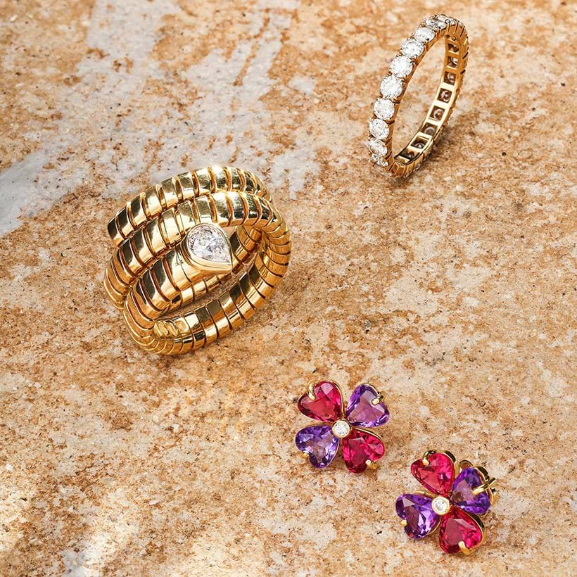 Inline Image - Clockwise: A Bulgari diamond 'tubogas' ring | Sold for £4,032. A Bulgari diamond eternity ring | Sold for £2,520. A pair of pink tourmaline, diamond and amethyst flowerhead Bulgari earrings | Sold for £2,772.