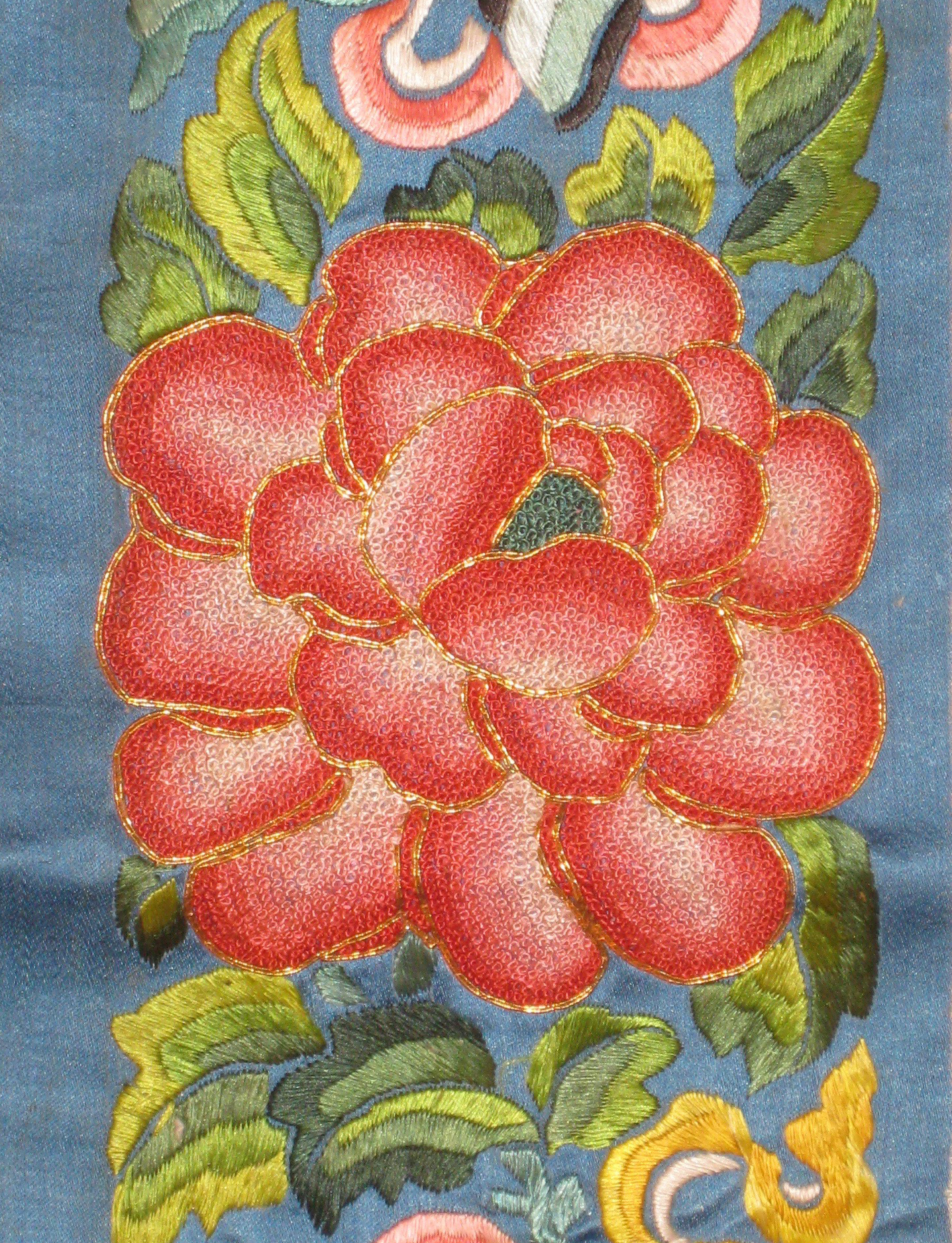 Inline Image - 19th century lady's sleeve decoration, with a large coral coloured peony embroidered in the 'Forbidden' knot | Photograph Courtesy of Linda Wrigglesworth Private Collection, London