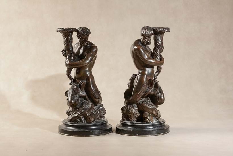 Inline Image - LOT 119: A PAIR OF PATINATED BRONZE FIGURAL CANDELABRA BASES CAST AS TRITONS, INSPIRED BY BERNINI AND TEDESCO AND AFTER DESIGNS BY JOSIAH WEDGWOOD AND MATTHEW BOULTON, FIRST QUARTER 19TH CENTURY | EST. £1,000-1,500 (+FEES)