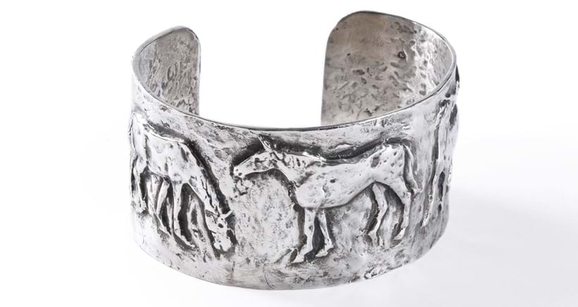 Inline Image - Lot 15 Philip Blacker Horses A sterling silver bangle The five horses in low relief, hallmarked and inscribed PB 7cm wide, 3.5cm high Similar works by this artist retail at: £400