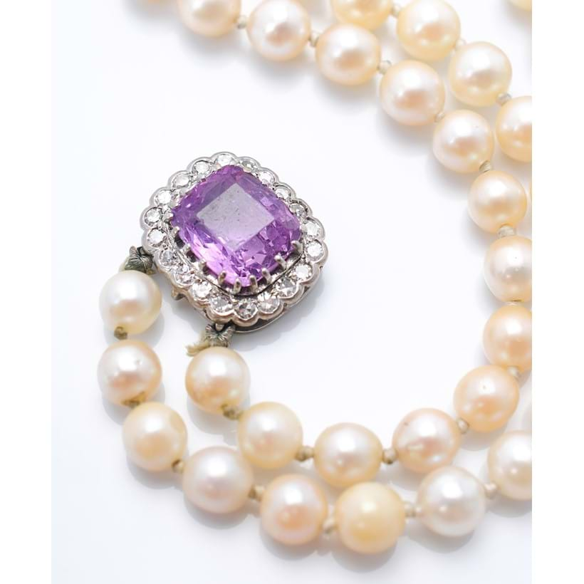 Inline Image - An early 20th century cushion shaped pink/purple sapphire set in a pearl necklace clasp. Sold at Dreweatts for £2,750