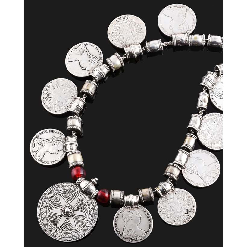 Inline Image - A ropework necklace, the barrel links suspending nine Maria Theresa Thaler restrike coins, and a circular plaque pendant with chase engraved decoration, glass beads interspersed, 70cm long