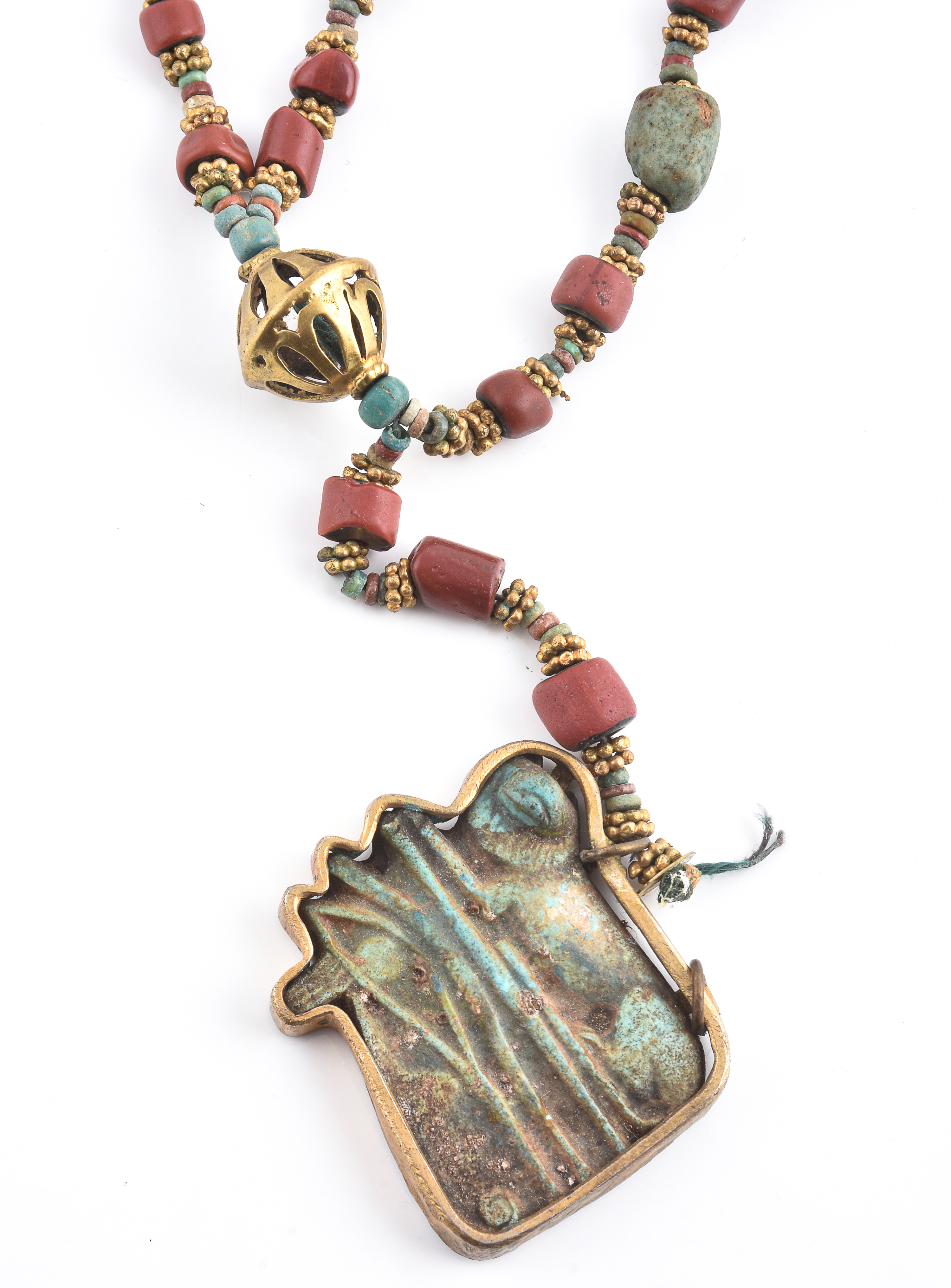 Inline Image - An Egyptian Revival coral and blue faience bead necklace, the barrel shaped coral beads and faience beads interspersed with granulated gilt metal rondels, suspending an Egyptian style blue composite amulet, the plaque carved to depict a reclining lion and the Eye of Horus, one drop missing, 38cm long