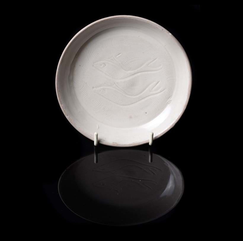 Inline Image - Lot 291: A rare small Chinese Ding style 'Twin Fish' dish, Song Dynasty, Provenance: John Sparks Ltd, 128 Mount Street, London until presumably sold to the late vendor in 1988 and by family descent. The Estate of Christopher and Rosemary Warren. | Est. £400-800 (+fees)