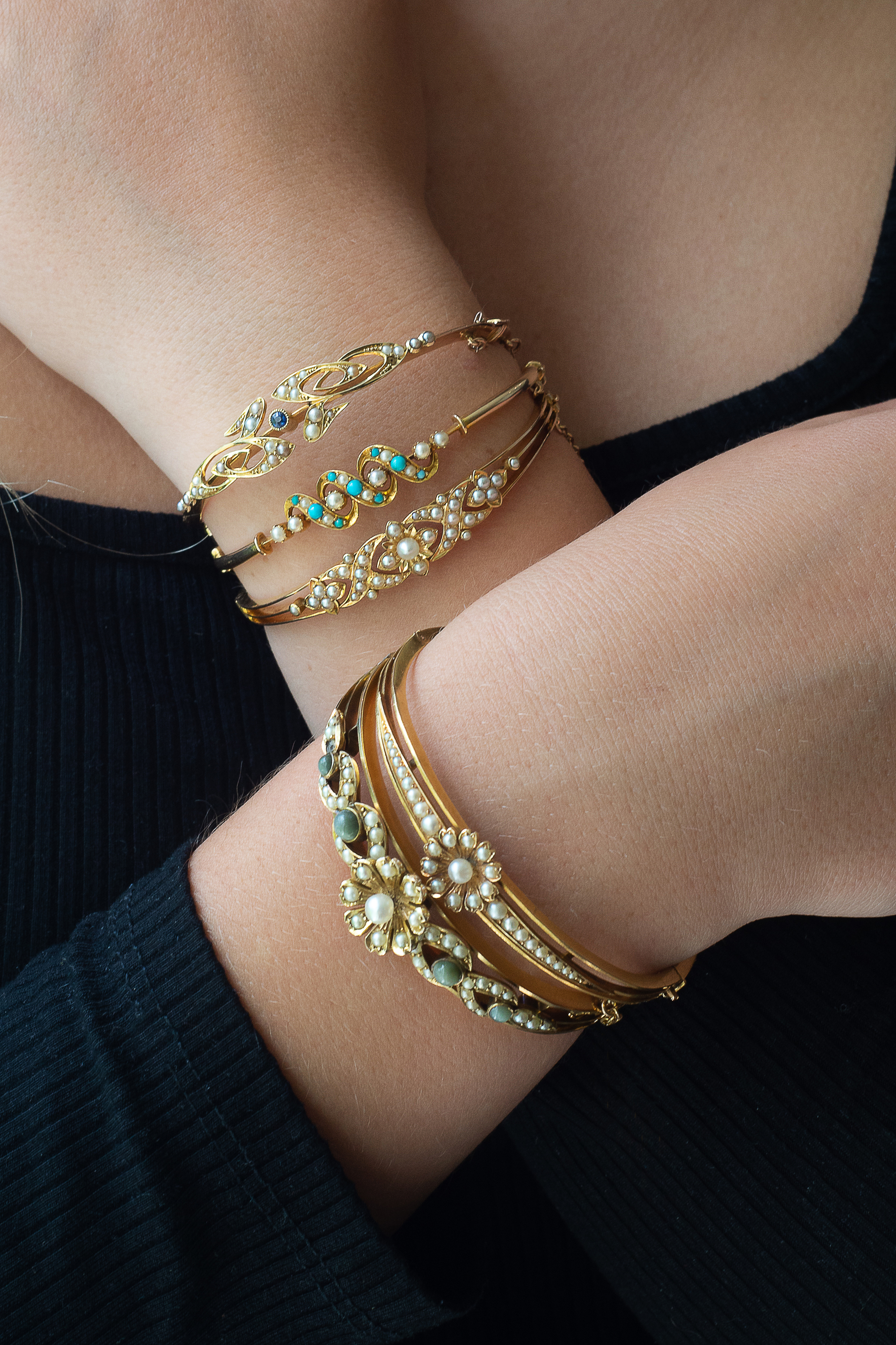 Inline Image - Lot 279: An Edwardian 15 carat gold, sapphire and half pearl bangle, circa 1905 | Est. £100-150 (+fees); Lot 183: A late Victorian turquoise and half pearl hinged bangle, circa 1900 | Est. £80-120 (+fees); Lot 271: An Edwardian half pearl hinged bangle, circa 1910 | Est. £100-150 (+fees); Lot 272: A late Victorian gold and half pearl hinged bangle, circa 1900 | Est. £120-180 (+fees); Lot 280: An Edwardian half pearl and cat's eye chrysoberyl hinged bangle, circa 1910 | Est. £300-400 (+fees)