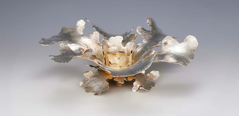 Inline Image - Lot 224: A silver coloured parcel gilt oak leaf candlestick or candle holder, Malcolm Appleby, Maker's Marks, unhallmarked, 2006 | Est. £2,000-3,000 (+ fees)
