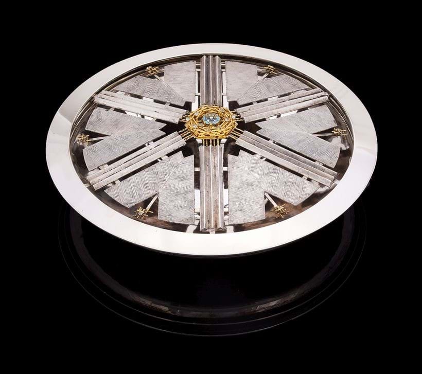 Inline Image - Lot 109: A silver circular table centrepiece with a removable unmarked gold coloured and aquamarine brooch, Gerald Benney, London 1965 | Est. £4,000-6,000 (+ fees)