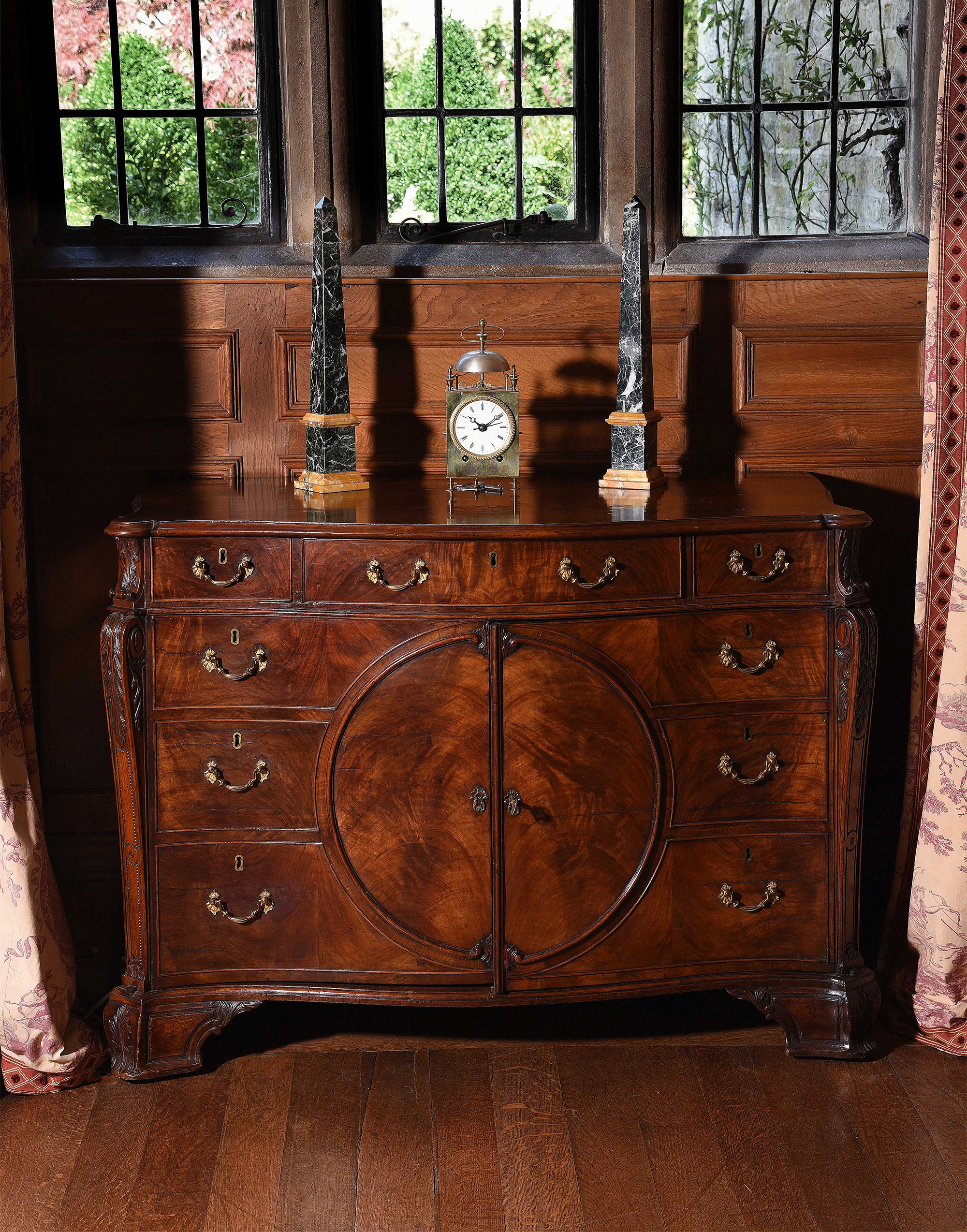 Inline Image - Lot 128: A George III figured mahogany serpentine commode, in the manner of Thomas Chippendale, circa 1770 | Est. £20,000-30,000 (+ fees)