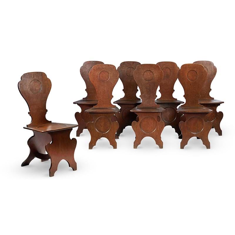 A set of eight George III oak hall chairs, circa 1780