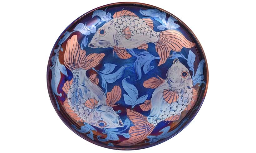 Inline Image - Lot 105: Jonathan Chiswell Jones for JCJ Pottery, a large reduction fired lustre porcelain charger, fired June 2022, decorated with a trio of fish and seaweed on a blue-purple ground | Est. £350-450 (+ fees)