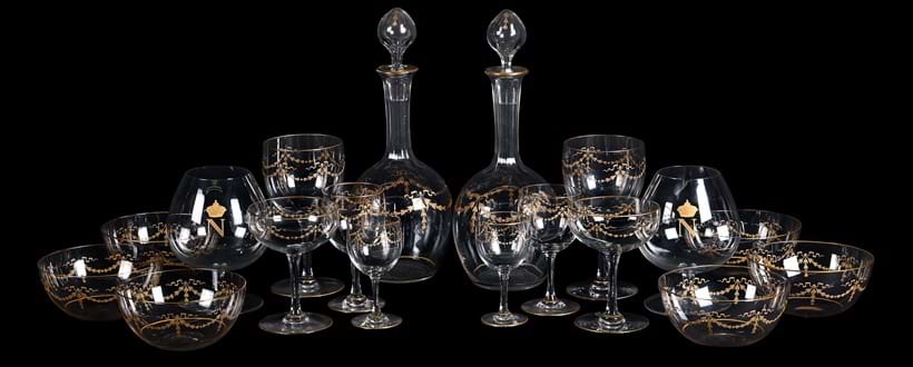 Inline Image - Lot 38: Eight Baccarat Napoleon III brandy balloon glasses, third quarter 19th century; And a part table service, possibly Baccarat, decorated with gilt swags, comprising: a pair of decanters and stoppers, 30cm high; six finger bowls, six champagne cups; six red wine goblets; three white wine and six liqueur glass, un-marked | Est. £500-700 (+ fees)