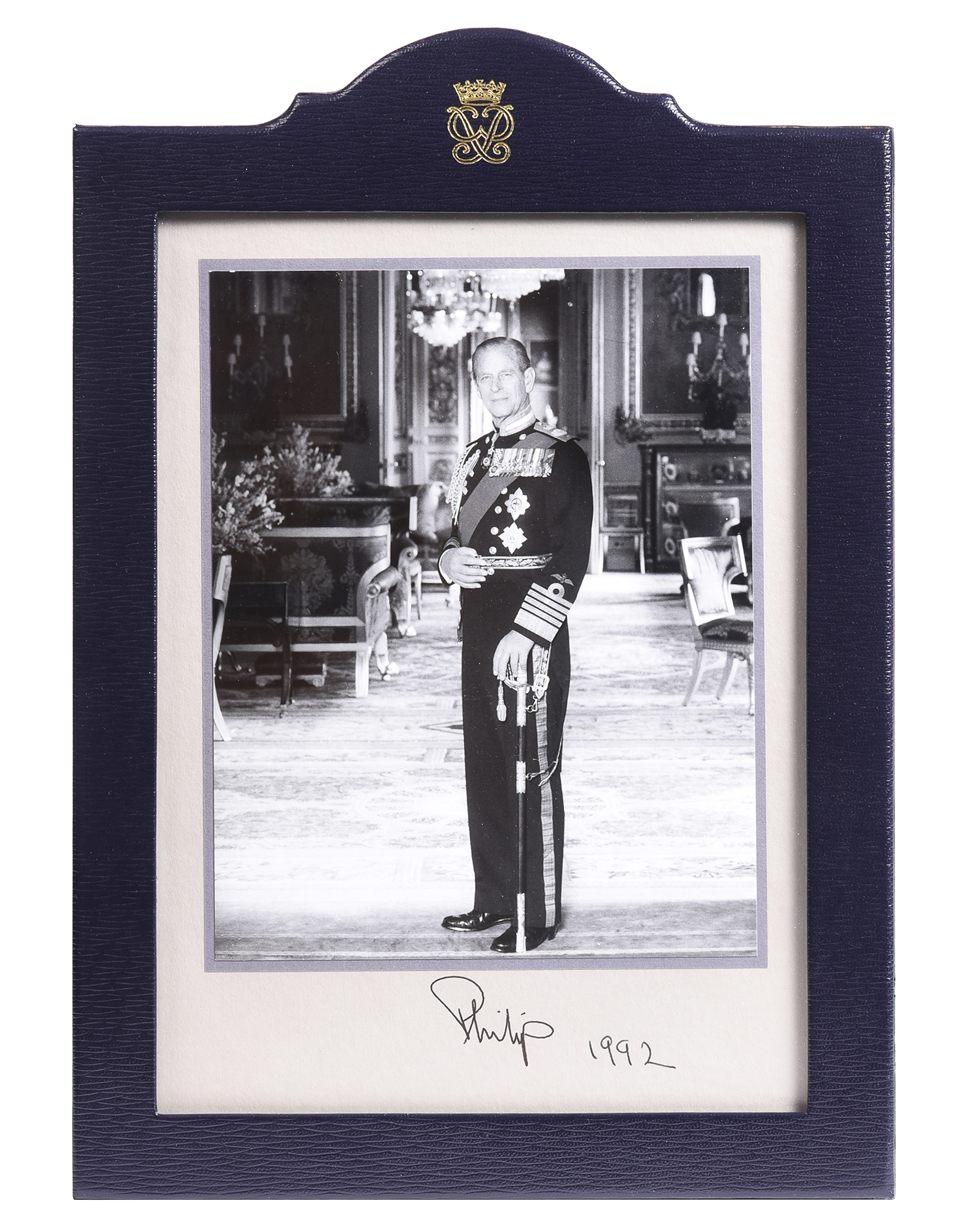 Inline Image - Lot 3: A signed and dated commemorative photograph of His Royal Highness, Prince Philip, Duke Of Edinburgh (1921-2021) in a Smythson Of Bond Street blue leather frame, signed and dated 1992 | Est. £150-250 (+ fees)