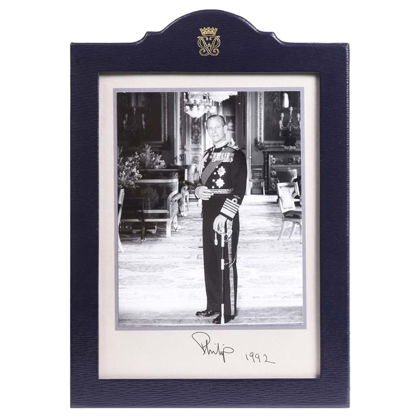 Inline Image - Lot 3: A signed and dated commemorative photograph of His Royal Highness, Prince Philip, Duke Of Edinburgh (1921-2021) in a Smythson Of Bond Street blue leather frame, signed and dated 1992 | Est. £150-250 (+ fees)