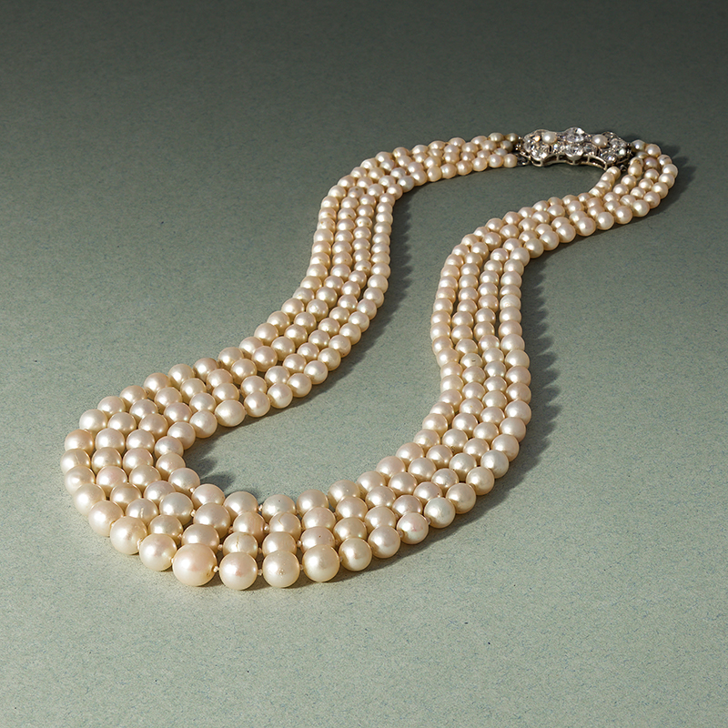 An early 20th century four row natural pearl and diamond necklace